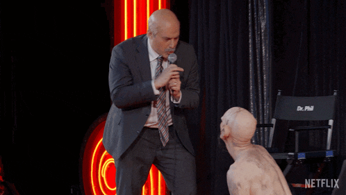 a man in a suit is dancing in front of a chair that says dr. phil
