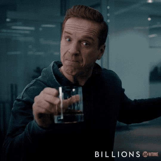 a man holding a glass of whiskey with the words billions showtime on the bottom