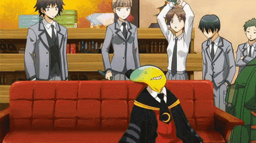 a group of anime characters are standing around a red couch with a man sitting on it .