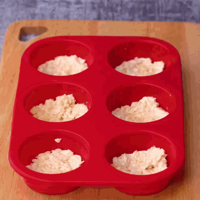 a red silicone muffin pan filled with white rice