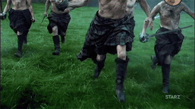 a group of men in kilts are running in a grassy field with the words starz on the bottom