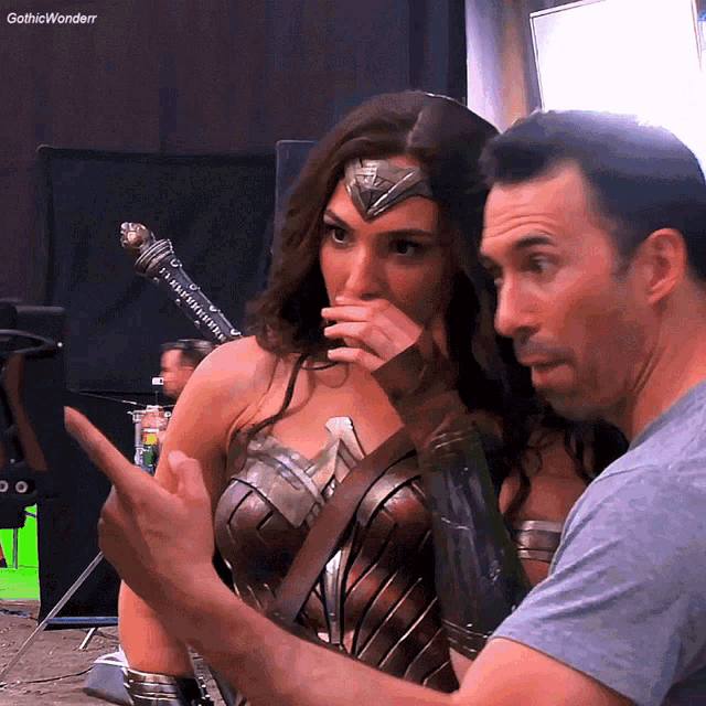 a woman in a wonder woman costume is talking to a man