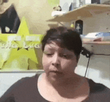 a woman is sitting in front of a shelf with a yellow star in the background .