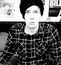 a black and white photo of a man wearing a plaid shirt and a blurry background