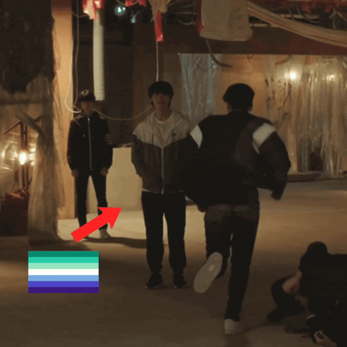 a group of people standing in a dark room with an arrow pointing to a flag that says asexual