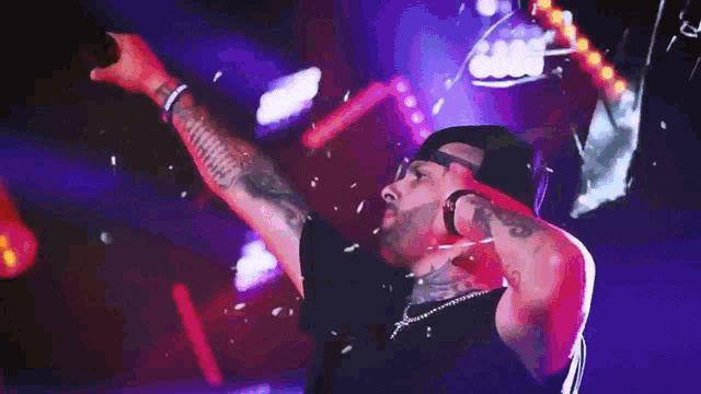 a man with a tattoo on his arm is dancing in a club