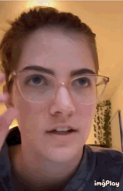 a close up of a woman wearing glasses with a gif play watermark