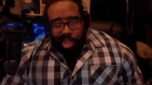 a man wearing glasses and a plaid shirt with the word yay in the corner
