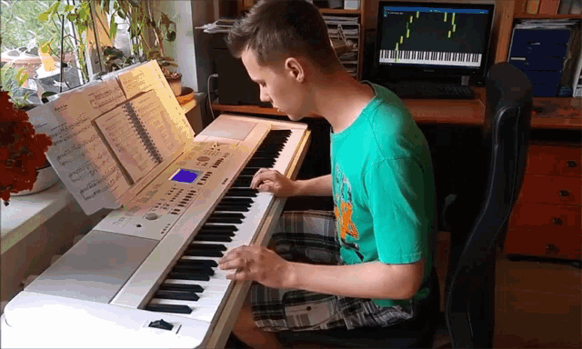 a man in a green shirt is playing a piano