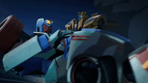 two transformers are sitting in a car and one has the word transformers on it