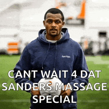 a man in a blue hoodie is holding a white hat with the words cant wait 4 dat sanders massage special