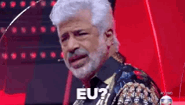 a man with white hair and a beard says eu on a red background