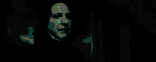 a close up of a person holding a wand in a dark room in a movie .