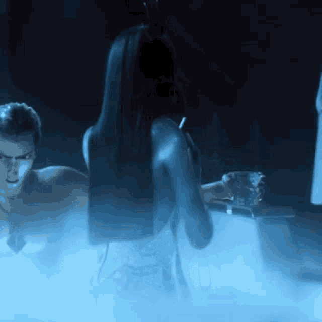 a man and a woman are standing in a bathtub with blue smoke coming out of it