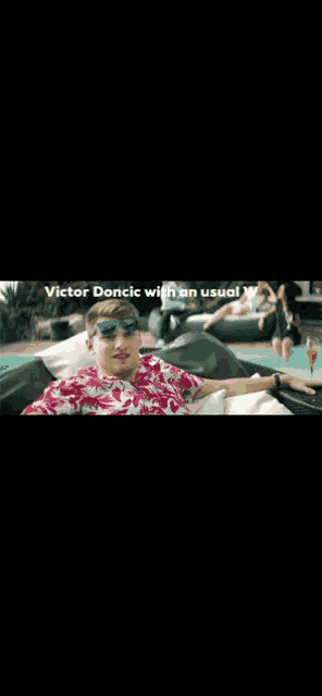 a man wearing sunglasses is laying by a pool with the words victor doncic with an usual