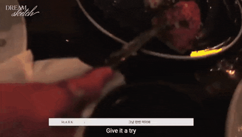 a person is holding a spoon over a bowl of food and the words give it a try are visible