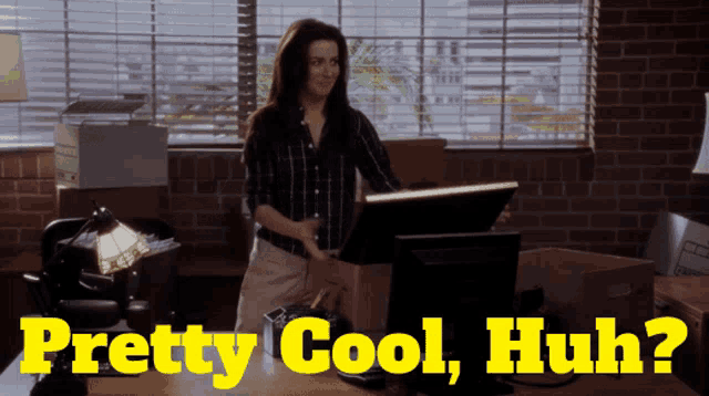 a woman standing in front of a computer with the words " pretty cool huh " behind her