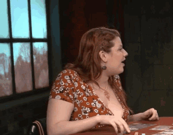 a woman in a floral top sits at a table