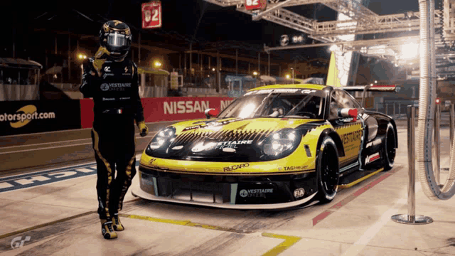 a man stands in front of a race car that says nissan on it