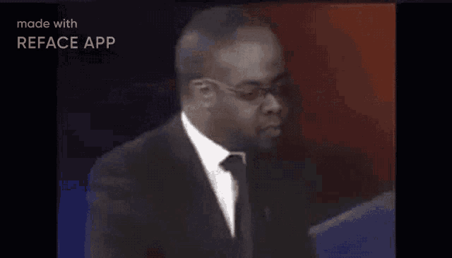 a man in a suit and tie is giving a speech on a stage .