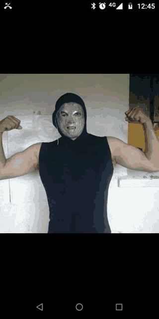 a man with a mask on his face flexing his muscles