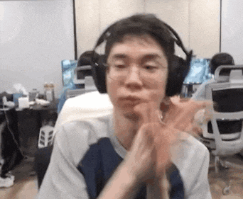 a man wearing headphones and glasses is clapping his hands in a room .