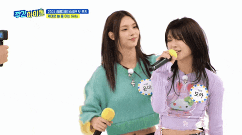 two girls singing in front of a microphone with a sign that says blue girls