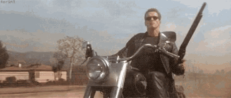 a man is riding a motorcycle with a gun on his shoulder .