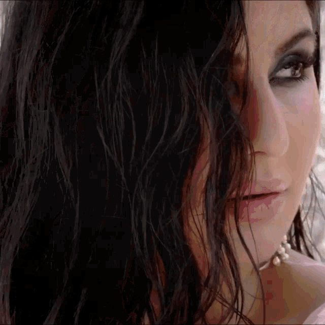 a close up of a woman 's face with her hair covering half of her face
