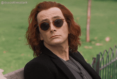 a man with long red hair is wearing sunglasses