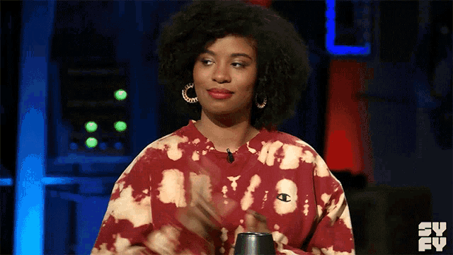 a woman wearing a red tie dye sweatshirt with a champion logo on the front