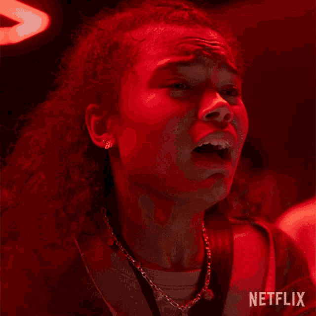 a woman is screaming in a red room in a netflix advertisement .