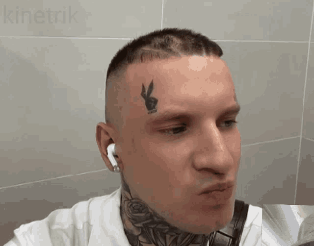 a man with a tattoo of a playboy bunny on his face