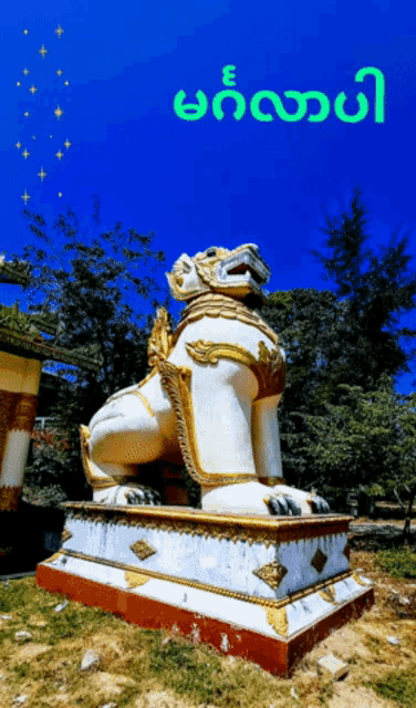 a statue of a lion with a blue sky in the background and the word e in green