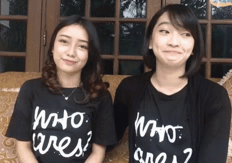 two women wearing who cares t-shirts are sitting next to each other