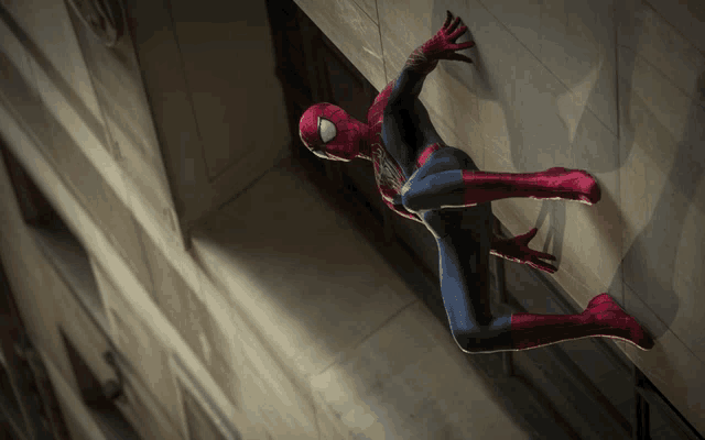 a man in a spiderman costume is climbing a wall