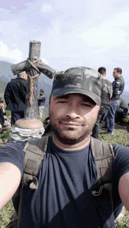 a man taking a selfie with a cross in the background and a man wearing a shirt that says ' freedom '