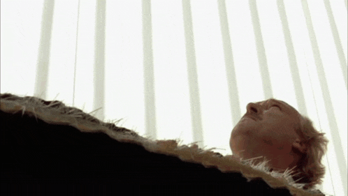 a man is laying down with his eyes closed and looking up at the sky .