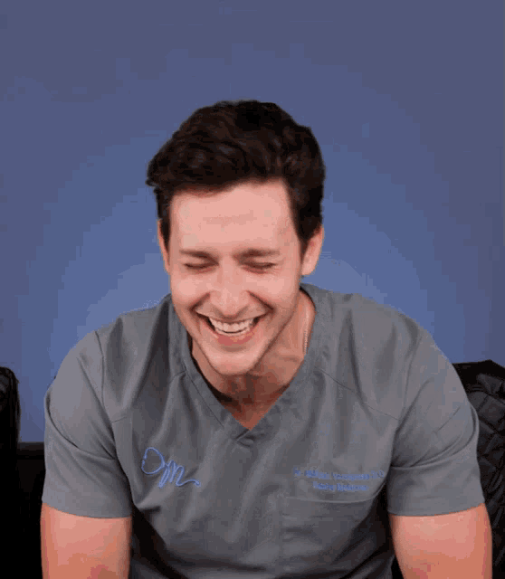 a man wearing a scrub top that says om on the front