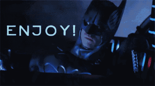 a man in a batman suit is talking on a cell phone with the words enjoy behind him