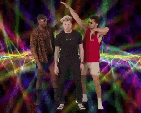 three men are dancing in front of a colorful background and one of them is wearing a red tank top that says gucci