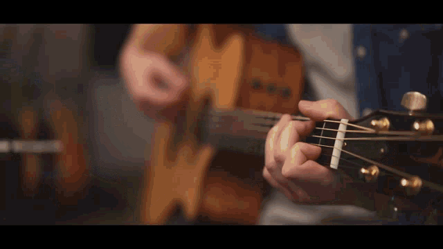 a man is playing an acoustic guitar with his fingers