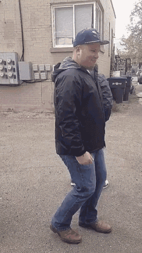 a man wearing a hat and a jacket is dancing