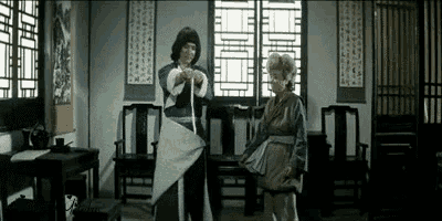 a man and a woman are standing in a room with chairs and a table .