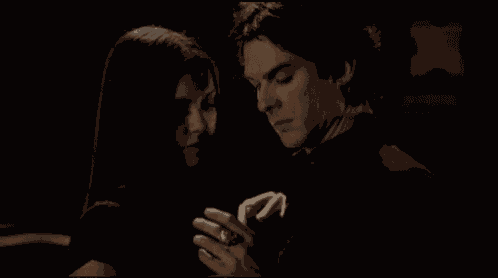 a man and a woman are looking at each other in the dark .