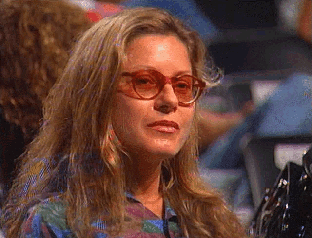 a woman wearing red glasses and a purple shirt