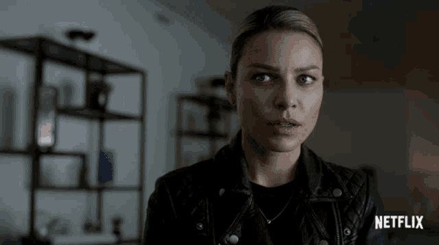 a woman wearing a black leather jacket with netflix written on the bottom