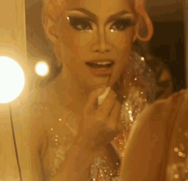 a woman is applying makeup in front of a mirror
