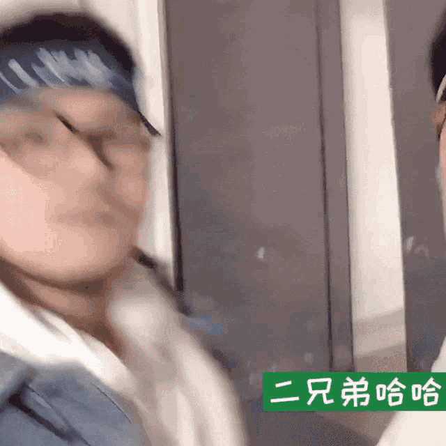 a man with a bandana on his head stands next to another man with chinese writing on it