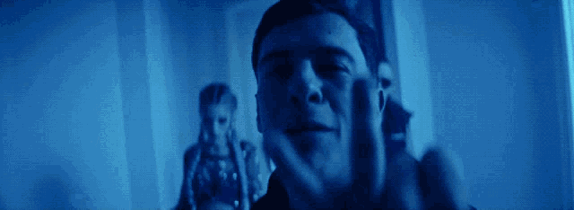 a man is screaming in a dark room with a woman in the background